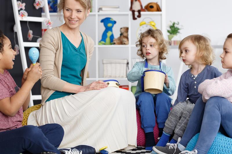 Pedagogisch professionals maakt muziek met de kinderen